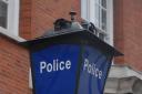 Police coax teenage down from Sutton police building