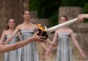 A torch is lit during the official ceremony of the flame lighting for the Paris Olympics, at the Ancient Olympia site, Greece (Thanassis Stavrakis/AP)
