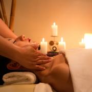 A woman having a massage in a candlelit room. Credit: Canva