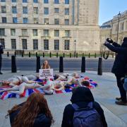 Molly Elsdon, 25, of Buckinghamshire sat in the middle of the action holding a sign reading, “Shot With Crossbows! 1 Cap = 1 Bear. MoD: Go Fur-Free.”