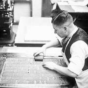 Compositor Frank Watson adds the final lines of type to a page
