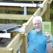 John Laker with solar panels and his Green Guide booklet