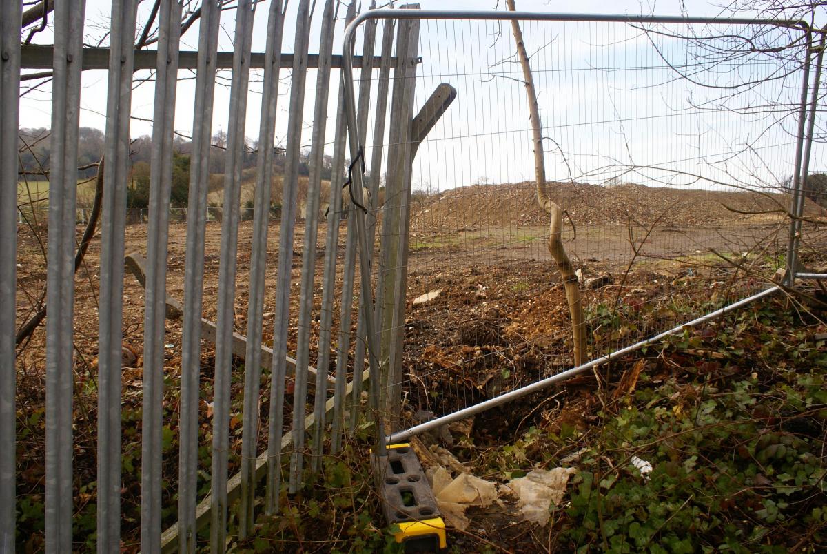 A gap in the fence next to the entrance to the site Photo Will Burton