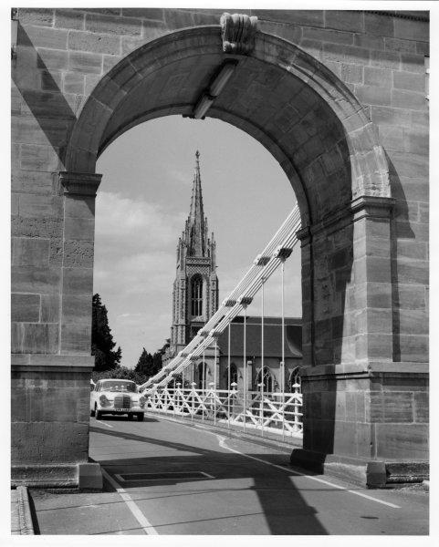 View through the archway of the southern suspension tower, of the bridge carriageway and parish church behind, Marlow Bridge, Marlow. 1967/68.
