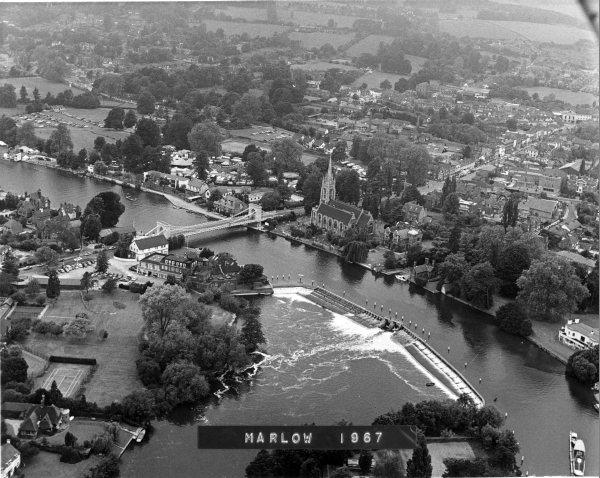 Looking NW from above Lock island, an aerial view of the weir, the river Thames, the town centre, and countryside beyond. Marlow. June 1967.