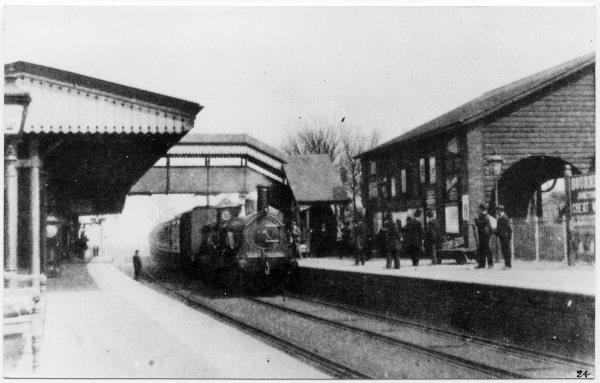 Looking west, a view of both platforms of the station, with a train at the north platform, and porters and passengers, Station Rd, Bourne End, 1890s.