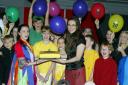 Clare Davies and students celebrate with a cake after the show