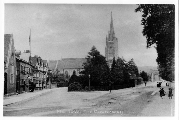 Looking South, with the parish church and entrance to the bridge in the background, a view of The Causeway, Marlow. Circa 1900
