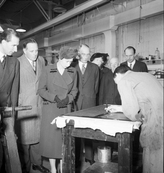 Queen Elizabeth II viewing work on enlarged master stamp artwork on her visit to Messrs. Harrison and Sons works, Hughenden Avenue, High Wycombe