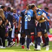Adebayo Akinfenwa consoles Ryan Tafazolli as Wycombe lose the League One play-off final (PA)
