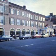 Looking north east across the street, a view of cars parked alongside the premises of Woolworths and the relocated Red Lion portico. High St, High Wycombe. Nov 1974