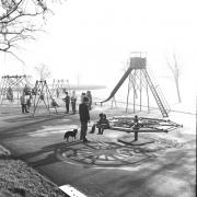 On a misty Boxing Day in 1965, families brave the cold to enjoy the playground facilities on the Rye, with the swing prominent.