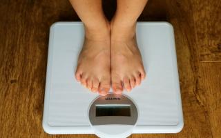 A young child is weighed on scales